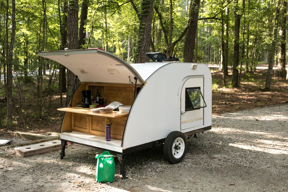A teardrop camper with the outdoor kitchen open.